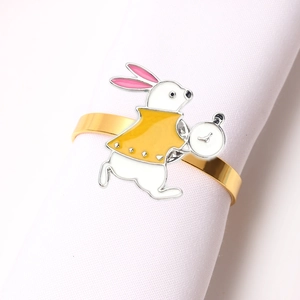 Detail of golden bunny napkin ring with white rabbit and enamel finish on table