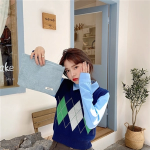 Close-up of light blue corduroy cosmetic bag held by model in casual outfit