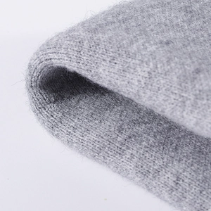 Gros plan d'un bonnet gris en maille montrant la texture douce et épaisse de la laine