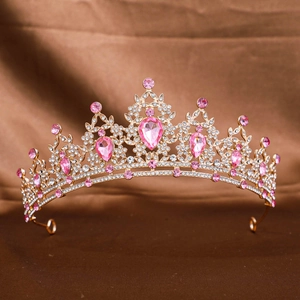 Luxurious gold bridal crown with pink water-drop rhinestones on silk background