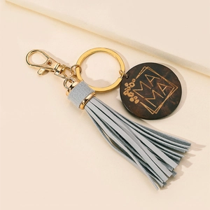 Detail of light blue PU tassel and gold metal ring with engraved MAMA wooden keychain