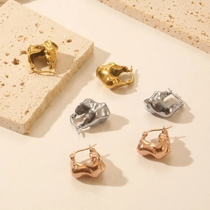 Macro detail of French vintage geometric C-shaped hoop earrings in gold, silver and rose gold