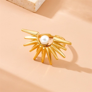 Golden sunburst ring with white pearl center on a minimalist stone display base