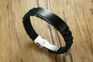 Detailed macro view of black silicone bracelet with stainless steel fold-over clasp