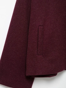Detailed close-up of dark wine red wool jacket sleeve and pocket with fine stitching