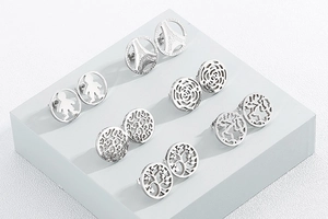 Detailed view of six pairs of round stainless steel studs with assorted hollow patterns