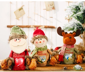 Close-up of three linen Christmas gift bags with Santa, snowman and deer designs