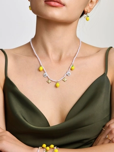 Dettaglio del set di gioielli con ciondoli a limone, margherite e perle ad alta lucentezza