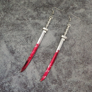 Detail of silver katana sword earrings with red blood stains and gothic metal finish