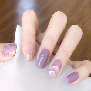 Macro shot of purple gradient press-on nails with gold glitter and marble texture design