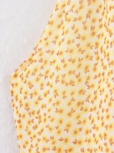 Vista macro del tessuto in chiffon leggero con stampa floreale gialla e trama intrecciata