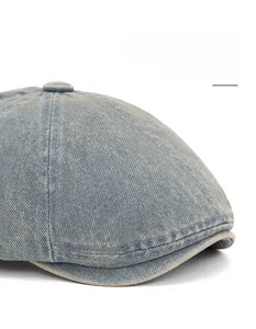 Detail of washed denim beret featuring adjustable curved brim and fine stitching craft