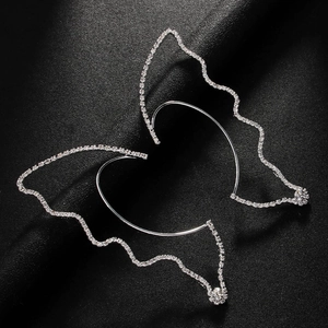 Sparkling silver butterfly ear cuffs with rhinestones on a textured black background