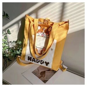 Detail of yellow canvas tote bag with cartoon corgi print and front pocket design
