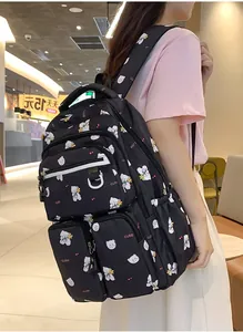 Detail of black student backpack featuring white bear prints and multi-pocket storage design