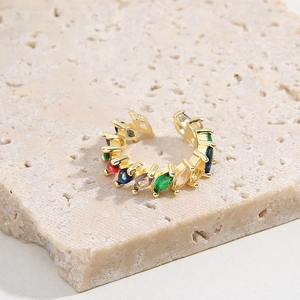 Adjustable gold plated ring featuring colorful marquise-cut zircons on stone background