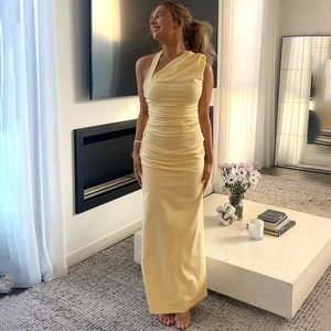 Close-up of elegant ruched detailing on the waist of a pale yellow one-shoulder maxi dress