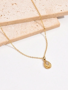 Detailed close-up of a teardrop-shaped gold necklace with a light oval gemstone on stone