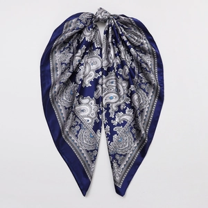 Detail of dark blue satin scarf showing silver paisley pattern and silky fabric texture