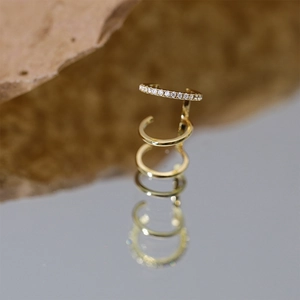 Macro detail of gold S925 sterling silver multi-layer ear cuff with marquise diamond accents