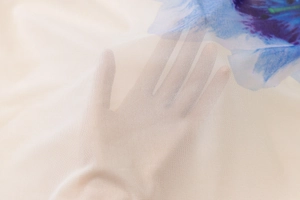 Close-up of semi-transparent floral mesh fabric showing breathable knit texture