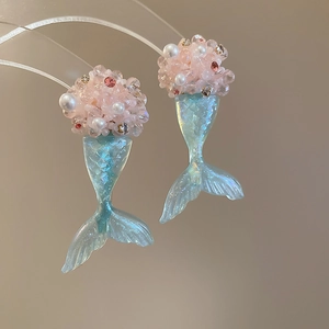 Detailed macro view of mermaid tail earrings with pink beads and colorful resin pearls