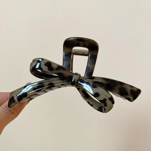 Detail view of the tortoiseshell acrylic bow hair claw with high-gloss finish and metal spring
