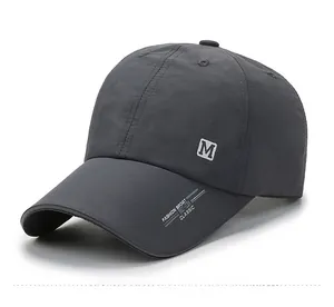 Detail view of dark grey quick-dry baseball cap with M embroidery and side vent holes