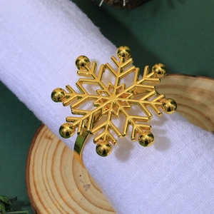 Close-up of golden snowflake napkin ring with rhinestones on a white linen napkin