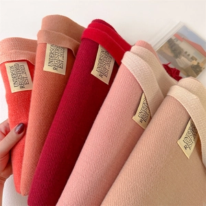 Stacked warm cashmere-like solid scarves in multiple colors with brand labels