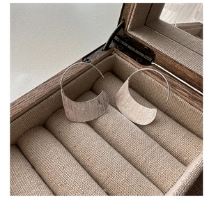 Detail view of S925 sterling silver hoop earrings with brushed texture on linen lining