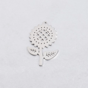 Macro detail of silver stainless steel sunflower pendant with cutout center and leaves