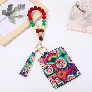 Close-up of tie-dye card holder with colorful wooden bead bracelet and gold keychain