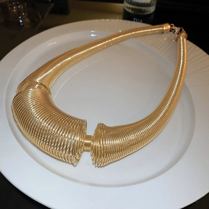 Exaggerated chunky gold spring coil necklace with bold industrial metal style for women