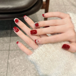 Short red French press-on nails with crystal accents and luxury holiday ruby design