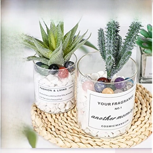 Polished natural crystal balls in various colors decorating a clear glass planter