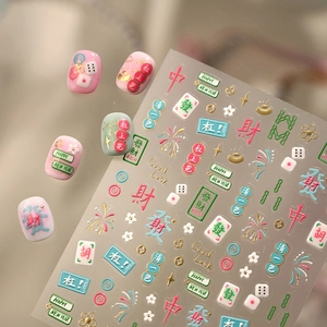 Detail of Mahjong nail stickers with embossed patterns and gold foil on pink and white nails