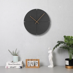 Close-up of modern round wall clock with dark grey dial and natural wooden hands