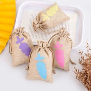 Detail of jute drawstring gift bags featuring colorful carrot silhouette patterns on fabric