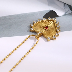 Nahaufnahme einer Vintage 18K Gold Herz-Halskette mit roten und weißen Steinen