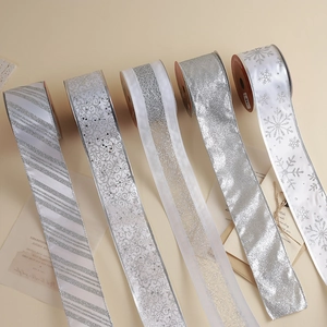 Five rolls of silver Christmas ribbons with glitter and snowflake patterns for gift wrapping