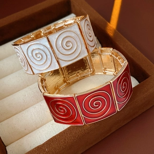 Detailed close-up of vintage enamel square bracelets in red and white with gold finish
