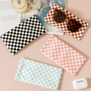 Flat lay of checkered PU leather pouches for makeup and accessories in four colors