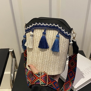 Chic beige woven bucket bag with black leather trim and colorful geometric strap