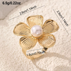 Macro detail of a gold flower ring with pearl inlay and specific size measurements