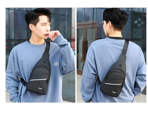 Close-up of black nylon men's chest bag featuring earphone port and front zipper pockets
