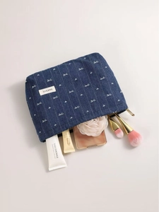 Denim bow cosmetic bag with white heart embroidery and striped quilting design