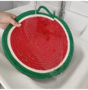 Washable woven watermelon placemat being rinsed under water to show easy cleaning feature
