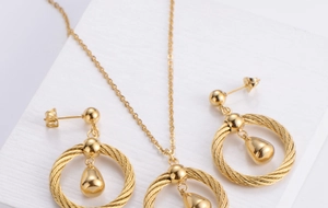 Macro shot of gold plated titanium steel teardrop pendant necklace and earrings jewelry set