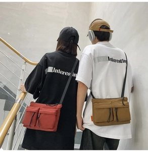 Rear view of red and khaki nylon messenger bags with dual front pockets for streetwear
